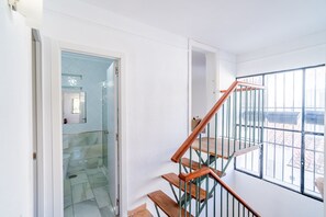 Una escalera con barandillas de madera y balaustradas de metal que conduce a un piso superior.