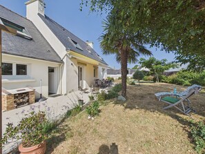 Ein Wohnhaus mit Terrasse, Sitzgelegenheiten im Freien, Grillplatz und Schwimmbad.