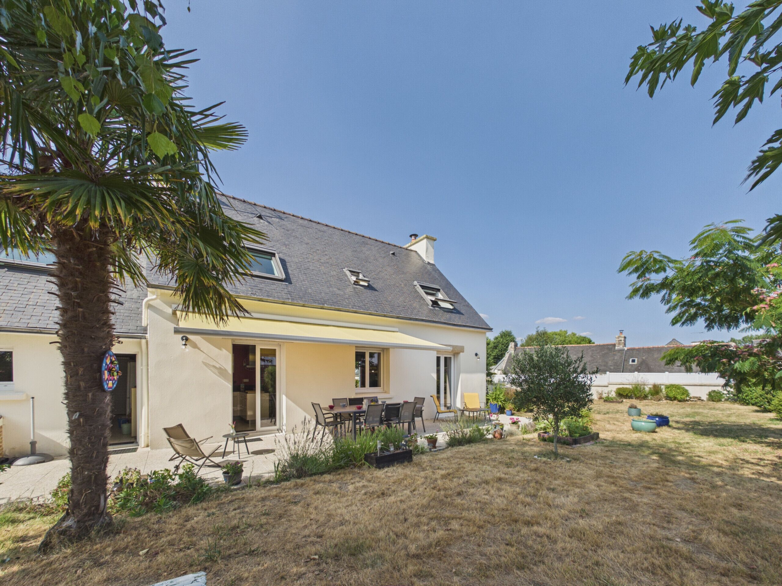 A residential house with a patio, a dining area, and a garden.