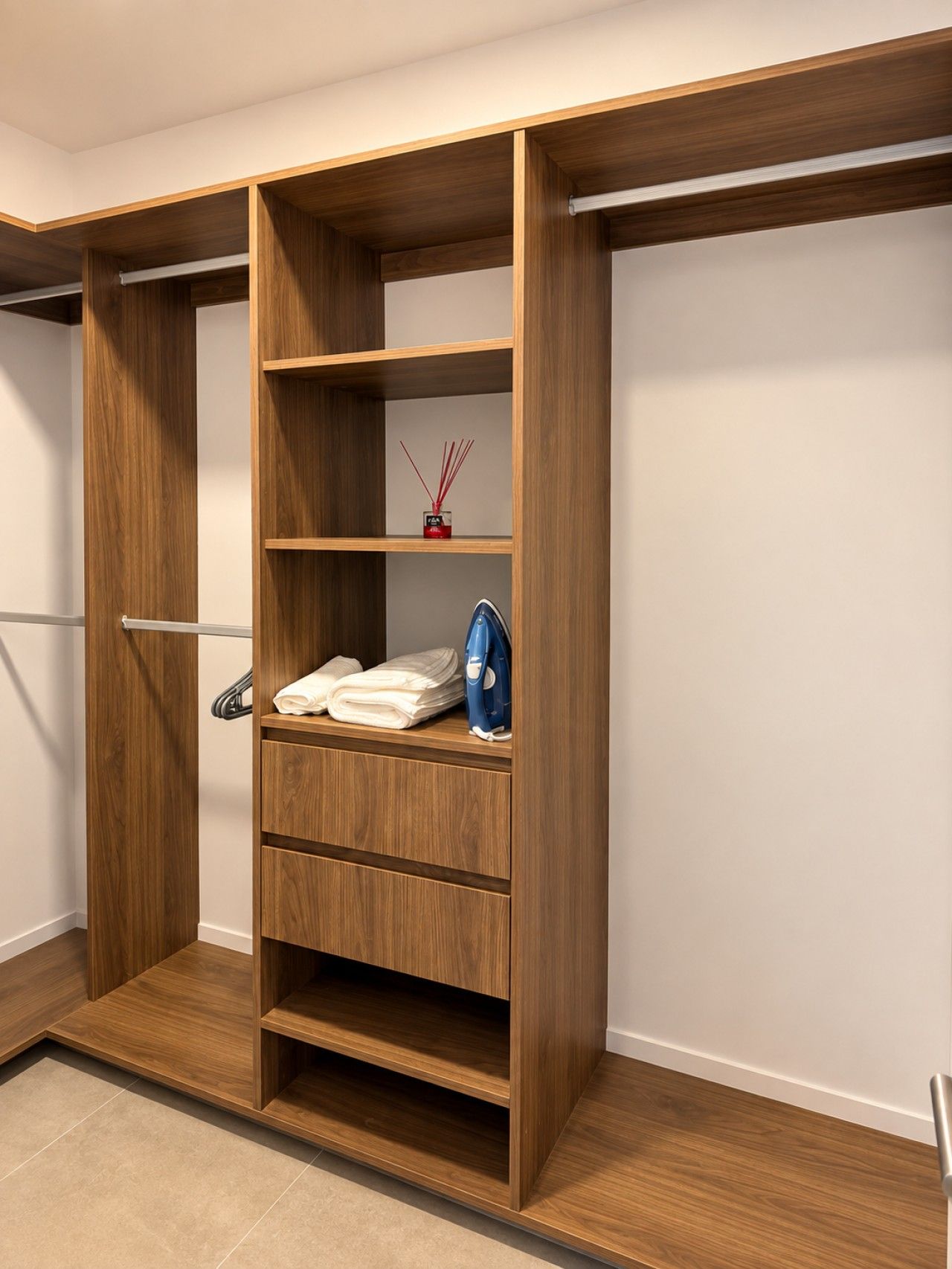 A wooden wardrobe with multiple shelves and a hanging rod, featuring a small decorative item on one of the shelves.