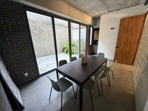 A conference room with a long table and six chairs, large windows, and a view of the outside. - Amazing new loft in LEF habitat (Guadalajara)