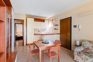 A compact living space with a dining area, kitchenette, and a bedroom.