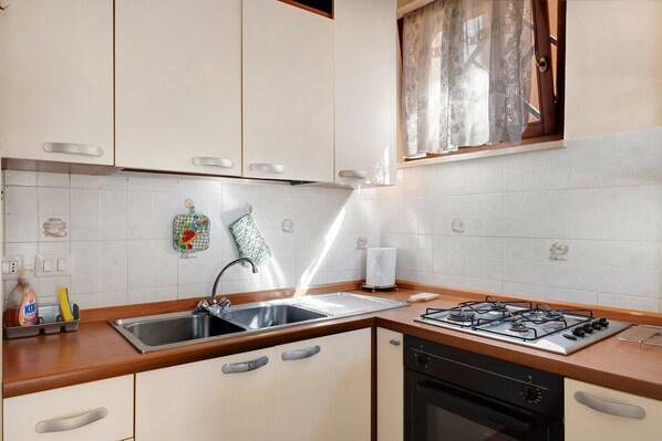 A kitchen with a sink, stove, and dishwasher.