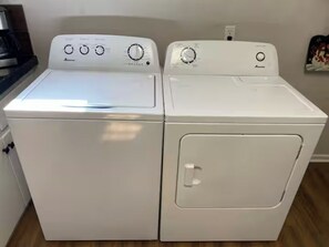 Two white front-loading washing machines side by side in a kitchen.