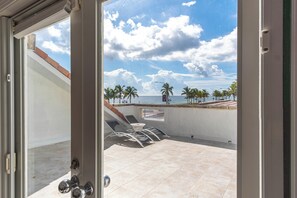 A patio with a view of the sea, palm trees, and a clear sky. - Luxury 6BR Beach Front House In Fort Lauderdale (Fort Lauderdale)