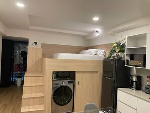 A compact room with a bunk bed, a washing machine, a microwave, and a coffee maker. - Torre Nous | A Pasos de Chapultepec+Seguridad 24/7 (Guadalajara)