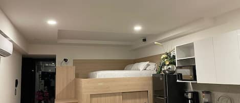 A compact living space with a bunk bed, kitchenette, and a small dining area.