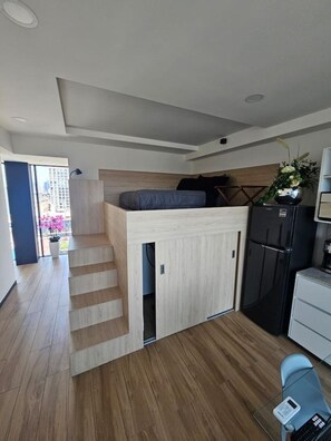 A compact living space with a kitchenette, a bed with a headboard, and a small dining area. - Torre Nous | A Pasos de Chapultepec+Seguridad 24/7 (Guadalajara)