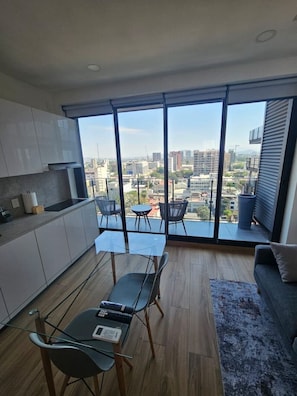 A modern kitchen with a dining area, large windows, and a city view. - Torre Nous | A Pasos de Chapultepec+Seguridad 24/7 (Guadalajara)