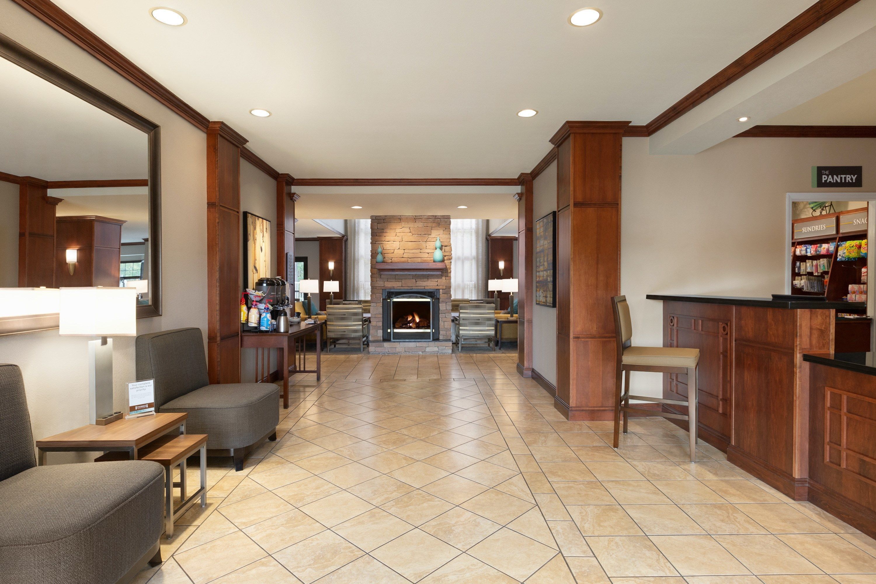 A spacious lobby with a fireplace, seating area, and a kitchenette.