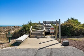 A wooden staircase leading to a beach area with a 'No Trespassing' sign and a sign indicating 'Owners & Guests Only' with restricted activities. - 3BR Direct Ocean Front Condo @ The Point! Point Emerald Villas A209 (Emerald Isle)