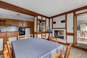 A compact kitchen with wooden cabinets, a refrigerator, and a stove. - Domaine de Trevety: Private Garden, Balcony & Wi-Fi, Ideal for Families & Groups (Châtillon-sur-Cher)