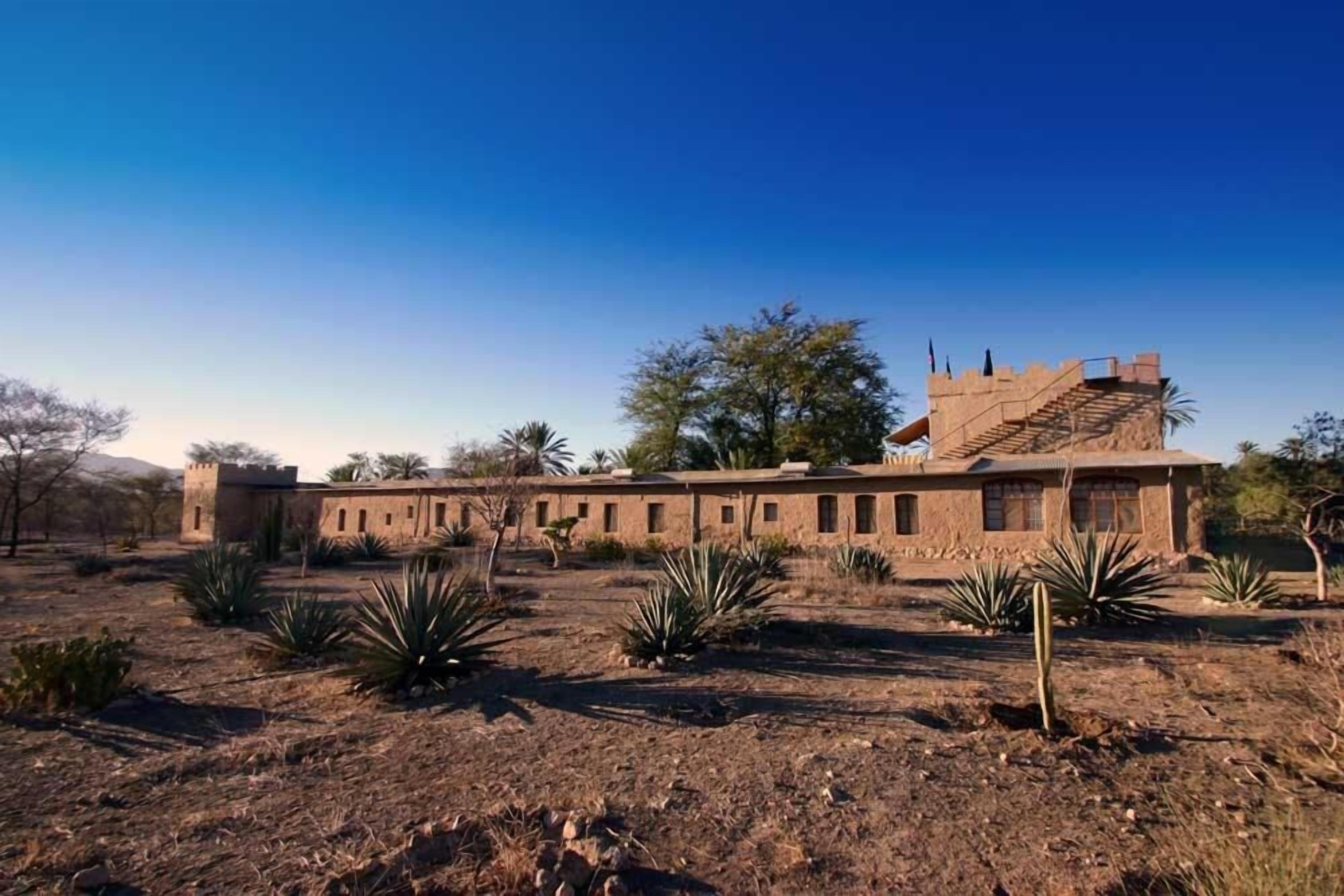 Un bâtiment doté d’un long toit plat et d’une structure en forme de tour sur le côté gauche.