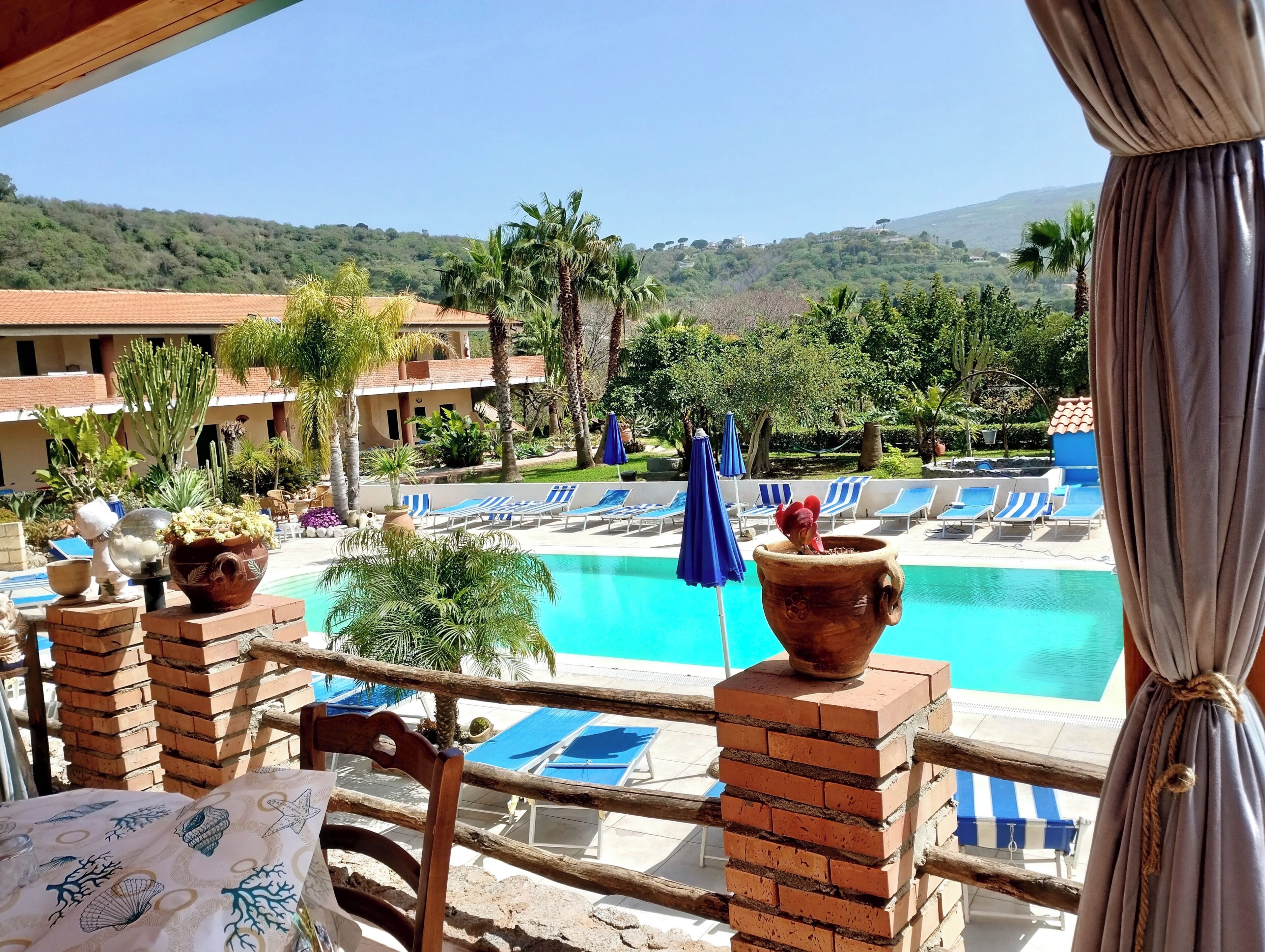 Una piscina al aire libre de temporada, sombrillas