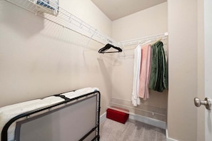 A small, compact room with a metal bed frame, a metal shelf unit, and a red storage box. - The Lofts of Downtown (540 N 2nd St, #210) (Clarksville)