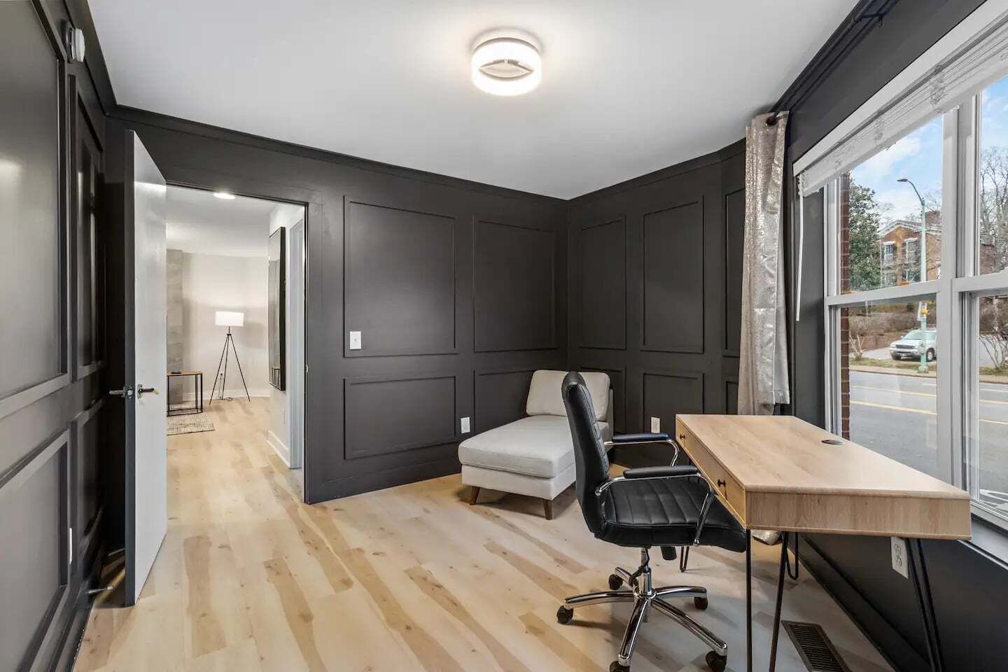 A room with a desk, chair, and a bed.