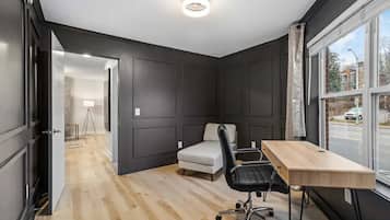A room with a desk, chair, and a bed.
