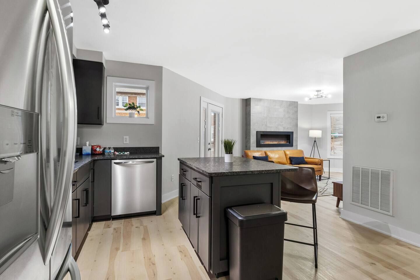 A modern kitchen with stainless steel appliances, a built-in dishwasher, and a central island with a sink.