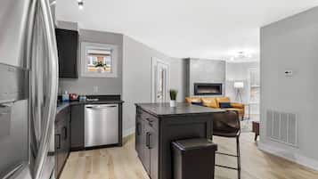 A modern kitchen with stainless steel appliances, a built-in dishwasher, and a central island with a sink.