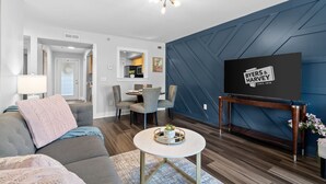 A modern living room with a sofa, coffee table, and TV on a stand. - The Lofts of Downtown (540 N 2nd St, #202) | Charming 2-Bedroom in the Heart of Clarksville, TN (Clarksville)