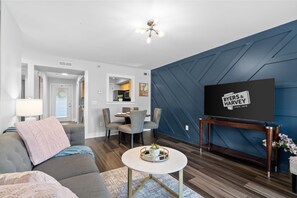 A modern living room with a sofa, coffee table, and TV on a stand. - The Lofts of Downtown (540 N 2nd St, #202) | Charming 2-Bedroom in the Heart of Clarksville, TN (Clarksville)