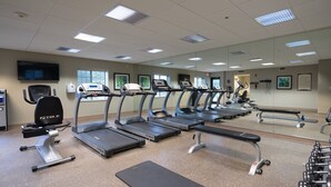 A gym with treadmills, exercise bikes, and weight machines.