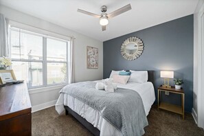 Ein Schlafzimmer mit Bett, Nachttisch und Deckenventilator.