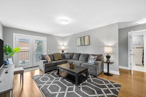 A modern living room with a sectional sofa, a coffee table, and a patterned rug. - The Lofts of Downtown (540 N 2nd St, #201) | Charming 2-Bedroom in the Heart of Clarksville, TN (Clarksville)