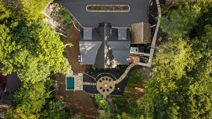 Vista aérea de uma propriedade com piscina, área de estar externa e um pátio circular.