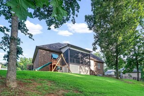 Une maison moderne avec une façade en briques, une grande baie vitrée et une terrasse en bois.