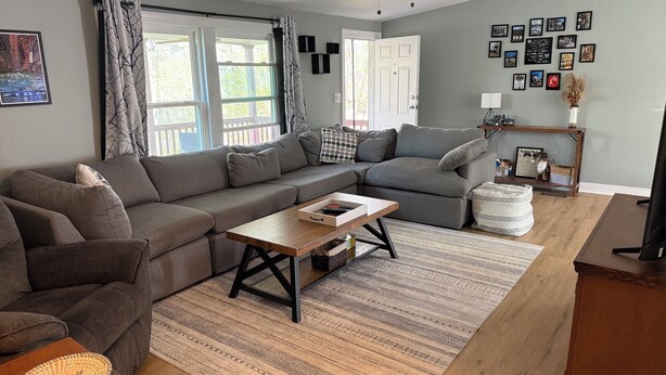 A living room with a sectional sofa, a coffee table, and a rug. - Cozy County Cottage- Pet friendly (Afton)