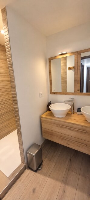 A modern bathroom with two sinks, a mirror, and a trash bin. - travelski home premium - Résidence La Mariande - 3 Pièces 6 personnes N°0.4 (Les Deux Alpes)