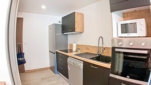 Una cocina moderna con microondas, horno, lavavajillas y armarios de madera.