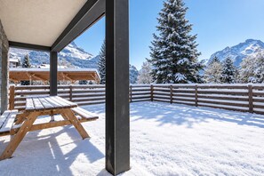 A snow-covered outdoor area with a wooden bench and a view of snow-covered mountains. - travelski home premium - Résidence La Mariande - 3 Pièces 6 personnes N°0.3 (Les Deux Alpes)