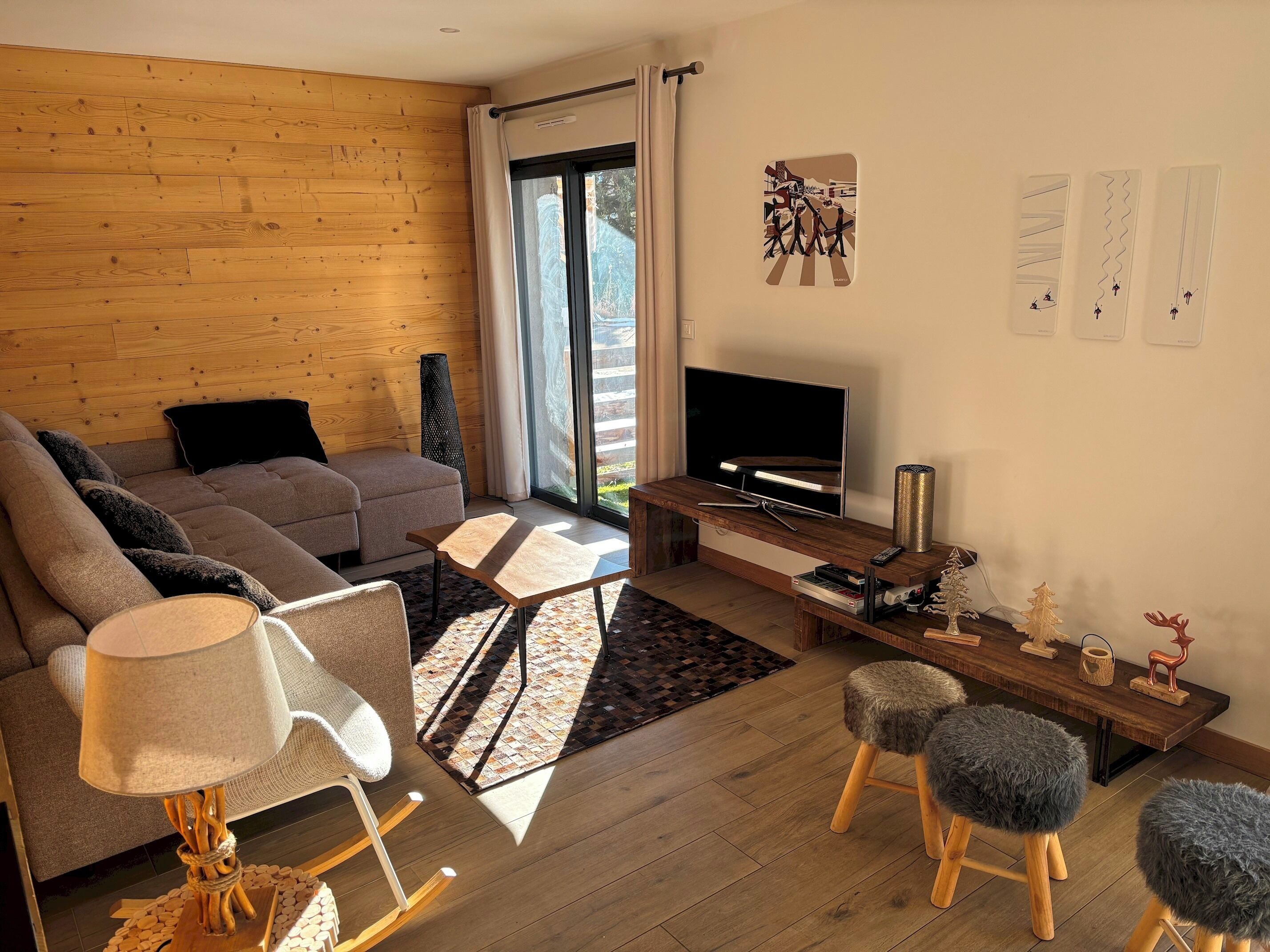 A modern living room with a sofa, a TV, a wooden coffee table, and a lamp.