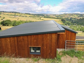 A wooden building with a metal roof, a small window, and a metal gate. - The Stables (Halifax)