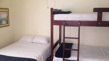 Uma beliche com escada, uma cama de solteiro e um quadro pendurado na parede.