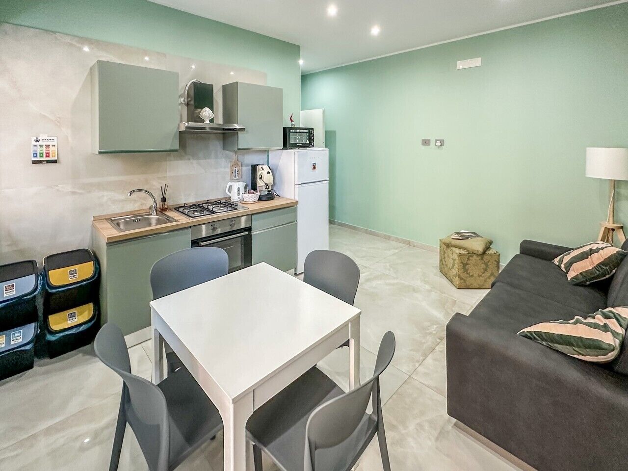 Un espacio habitable compacto con kitchenette, comedor y zona de estar.