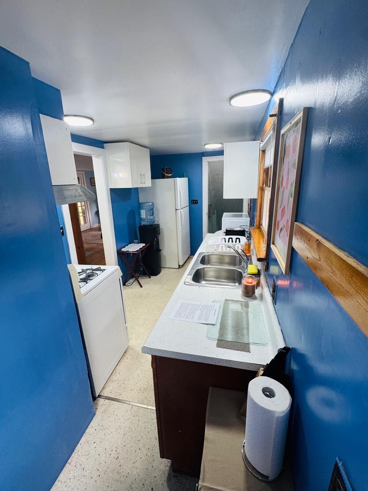 A compact kitchen with white cabinets, a sink, and a stove.
