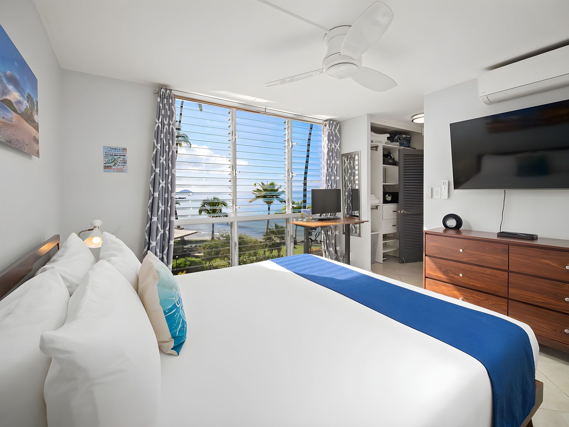 Habitación de hotel con una cama, un escritorio, un televisor y vistas al exterior.