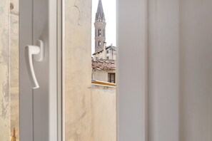 Blick durch eine offene Tür auf ein Gebäude mit einem Turm.