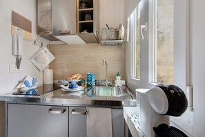 Una cocina moderna con un lavamanos de acero inoxidable, horno empotrado y ventana con vistas.
