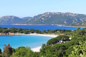 A coastal landscape with a beach, clear blue waters, and a mountain range in the background. - Casa di Toro:House in front of the sea at Palombaggia, 2/8 p (Porto-Vecchio)