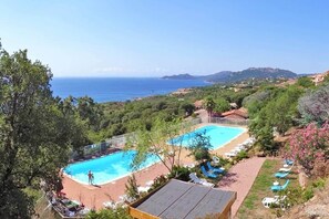Un complexe hôtelier doté de deux piscines, d’une plage et offrant une vue sur la mer et les collines.