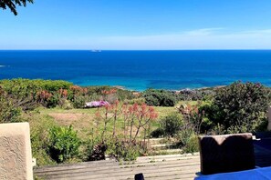 A coastal landscape with a view of the sea, vegetation, and a wooden deck. - Casa di Toro:House in front of the sea at Palombaggia, 2/8 p (Porto-Vecchio)