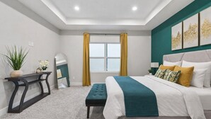 A bedroom with a bed, bedside table, and a window with curtains. - Designer 3BR w/ Fireplace, Yard & Free Parking (Houston)