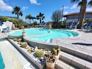 A swimming pool with a tiled edge, surrounded by lounge chairs and potted cacti. - Residence with swimming pool in Capo Vaticano (Santa Maria)