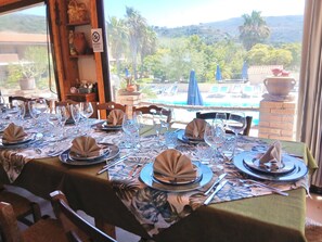A dining table set for a meal with a view of a pool and mountains. - Residence with swimming pool in Capo Vaticano (Santa Maria)