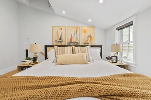 A bedroom with a large bed, two bedside tables, a window, and a wall with three paintings. - North End Entire House / Heart of Boston (Boston)