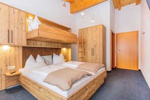Ein Zimmer mit einem Etagenbett, einem Holzschrank und einer Tür.